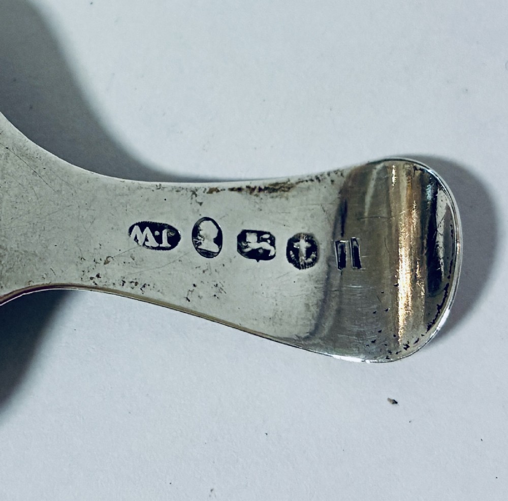 A Georgian sterling silver caddy spoon with a rectangular shovel-form bowl and bright-cut engraved geometric patterns on the handle. View VIII