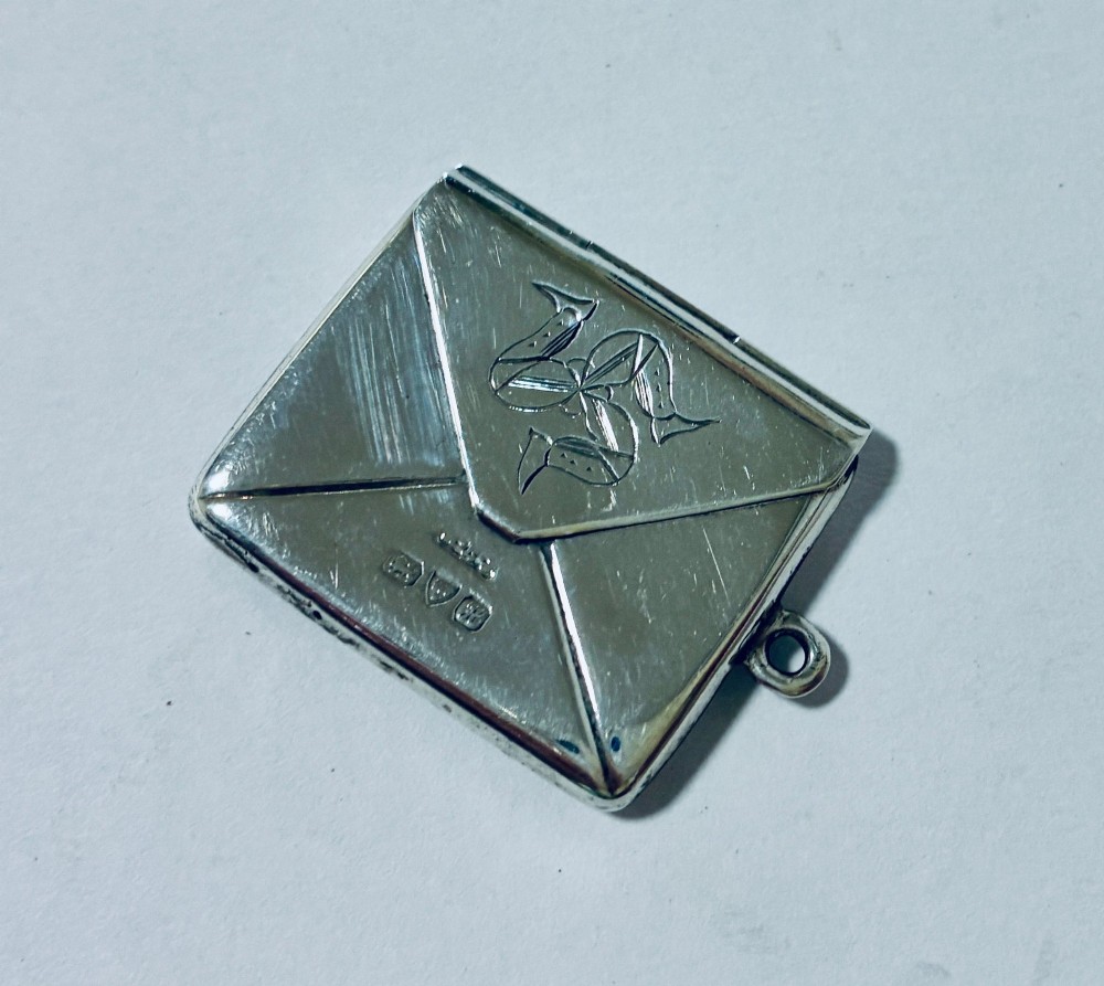 An envelope-shaped sterling silver stamp case featuring an engraved Isle of Man triskelion and clear hallmarks.