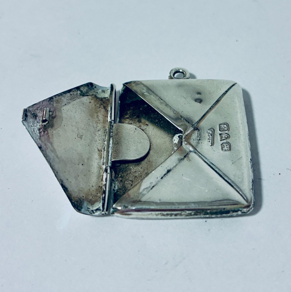 An envelope-shaped sterling silver stamp case featuring an engraved Isle of Man triskelion and clear hallmarks. View VI