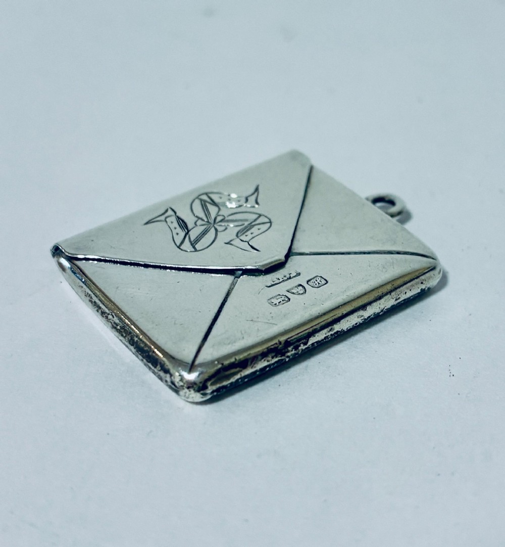 An envelope-shaped sterling silver stamp case featuring an engraved Isle of Man triskelion and clear hallmarks. View VII
