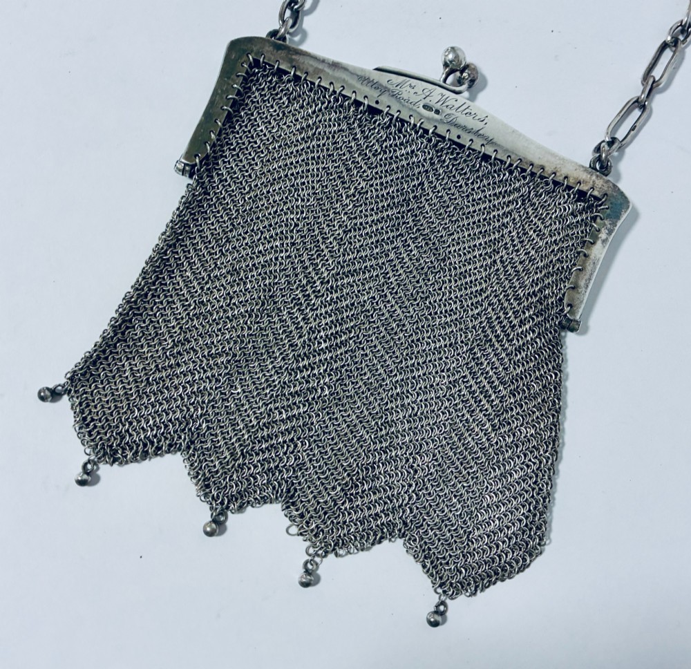 An Art Deco silver mesh purse featuring an engraved kiss-lock frame, a paperclip link chain handle, and a scalloped hem with drop-bead detailing. View II