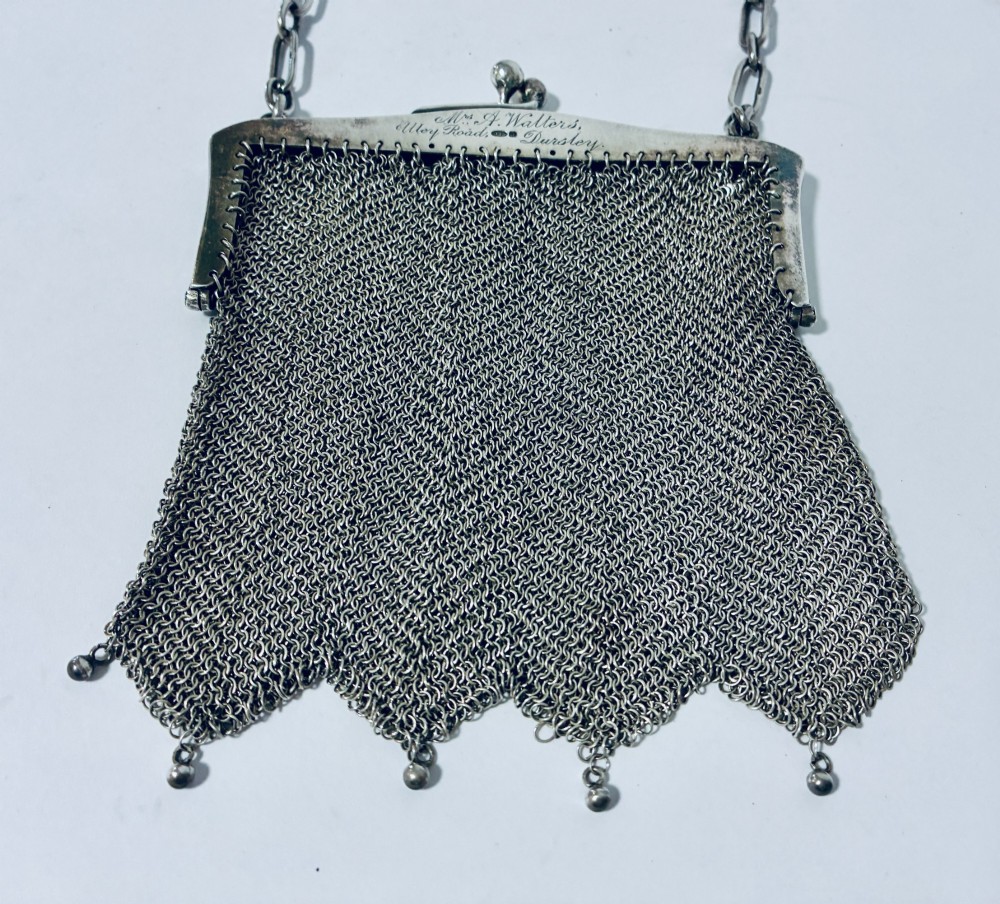 An Art Deco silver mesh purse featuring an engraved kiss-lock frame, a paperclip link chain handle, and a scalloped hem with drop-bead detailing. View III