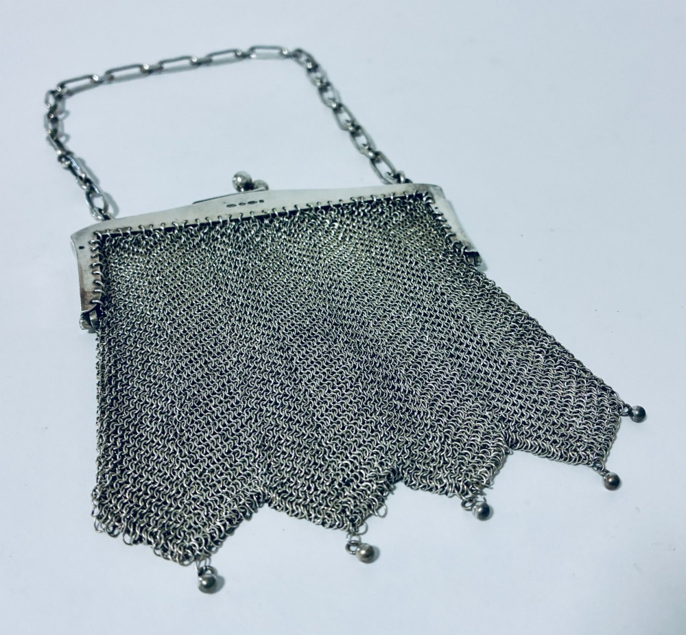 An Art Deco silver mesh purse featuring an engraved kiss-lock frame, a paperclip link chain handle, and a scalloped hem with drop-bead detailing. View VI