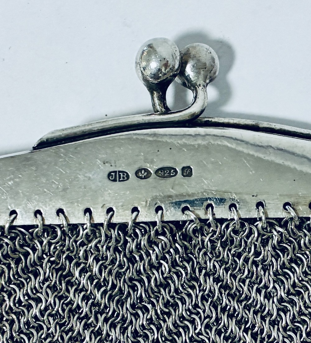 An Art Deco silver mesh purse featuring an engraved kiss-lock frame, a paperclip link chain handle, and a scalloped hem with drop-bead detailing. View VII