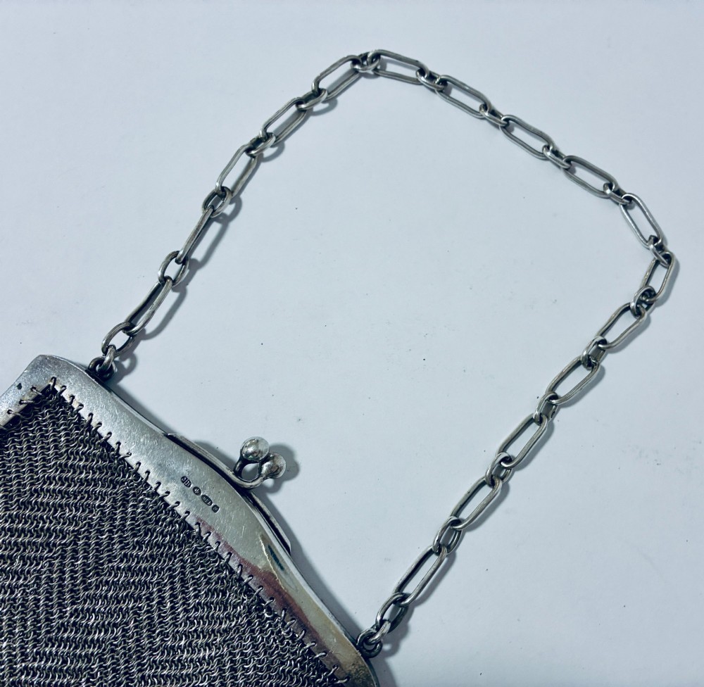 An Art Deco silver mesh purse featuring an engraved kiss-lock frame, a paperclip link chain handle, and a scalloped hem with drop-bead detailing. View VIII