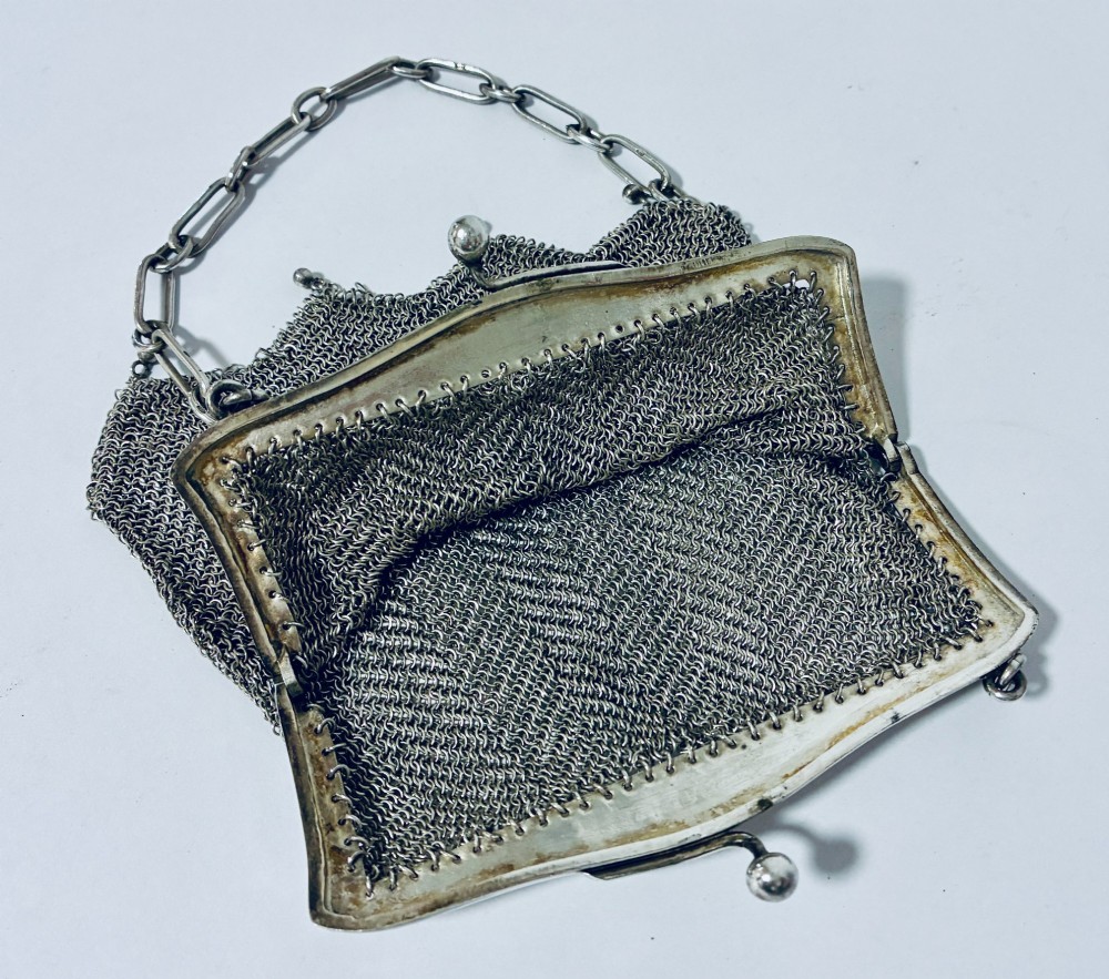 An Art Deco silver mesh purse featuring an engraved kiss-lock frame, a paperclip link chain handle, and a scalloped hem with drop-bead detailing. View IX
