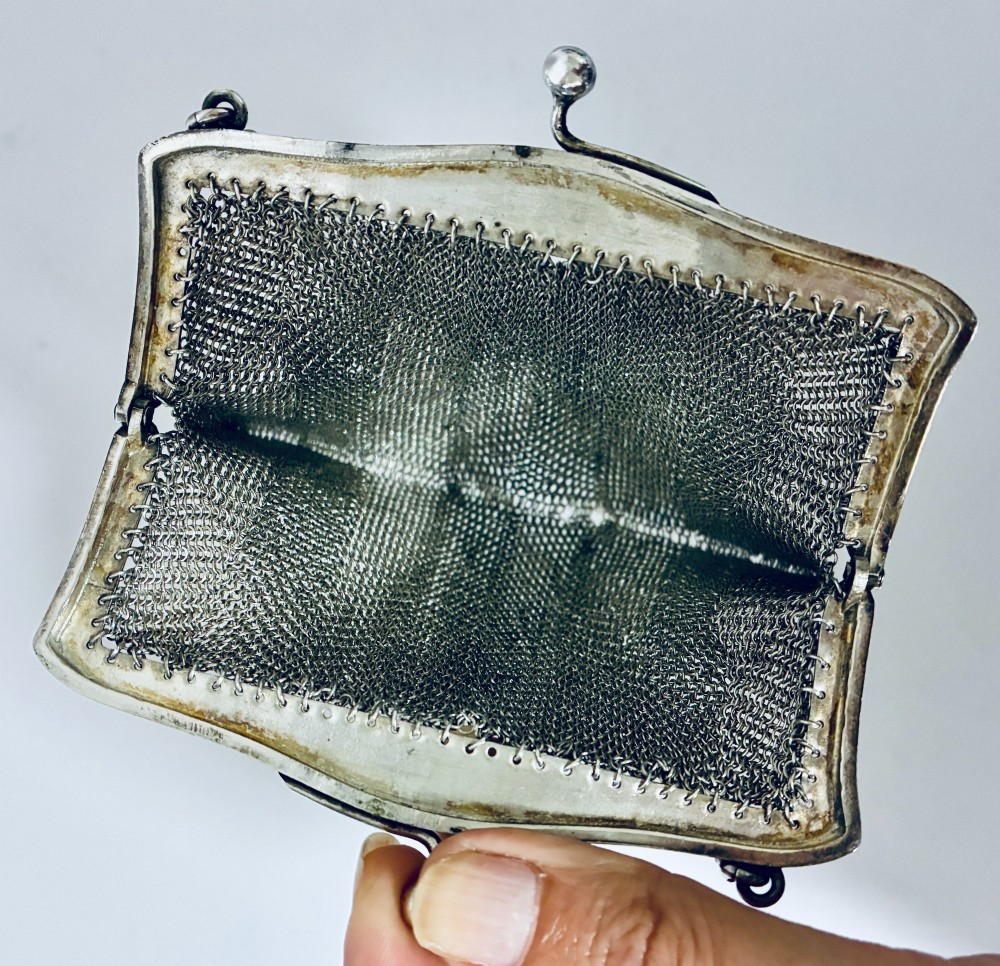 An Art Deco silver mesh purse featuring an engraved kiss-lock frame, a paperclip link chain handle, and a scalloped hem with drop-bead detailing. View X