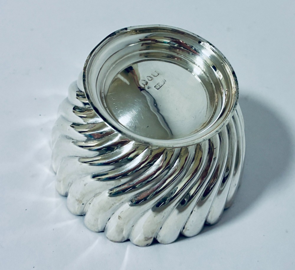 An antique silver pedestal bowl featuring spiralled fluted sides and a scalloped rim resting on a round moulded base. View V