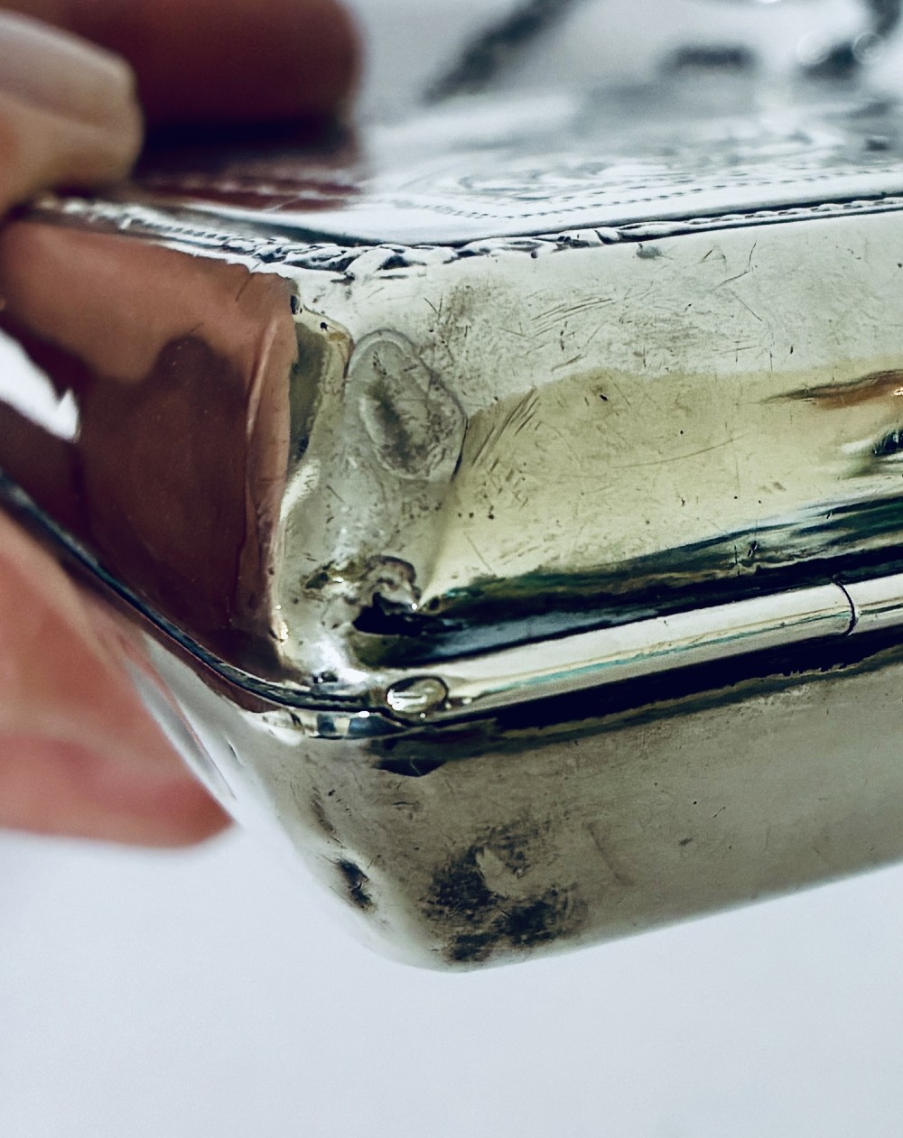 An antique sterling silver evening purse featuring engraved floral scrollwork, visible hallmarks along the upper frame, and a chain handle with a finger ring. View XIII