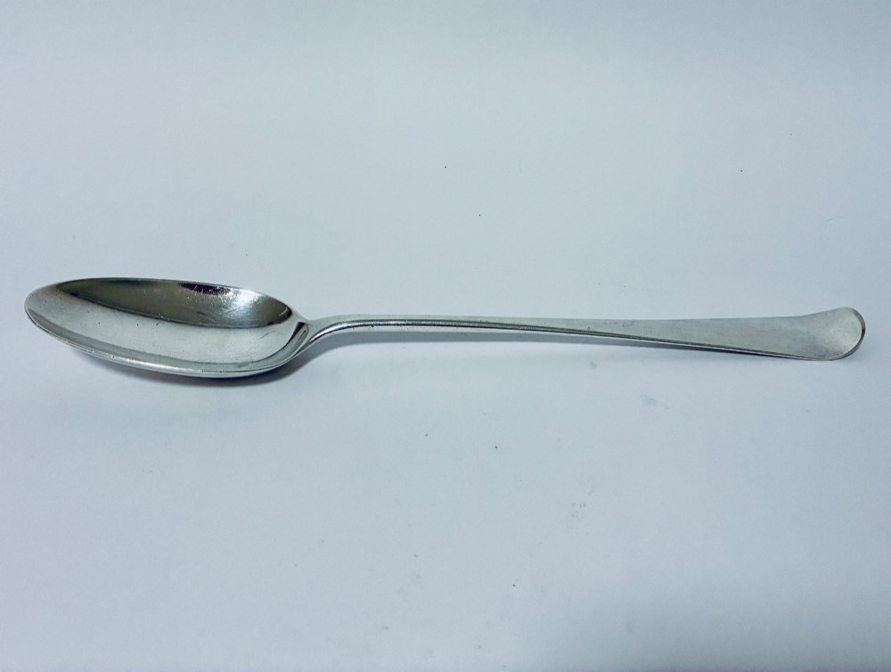 An 18th-century silver serving spoon featuring an elongated oval bowl and a smooth tapered handle.