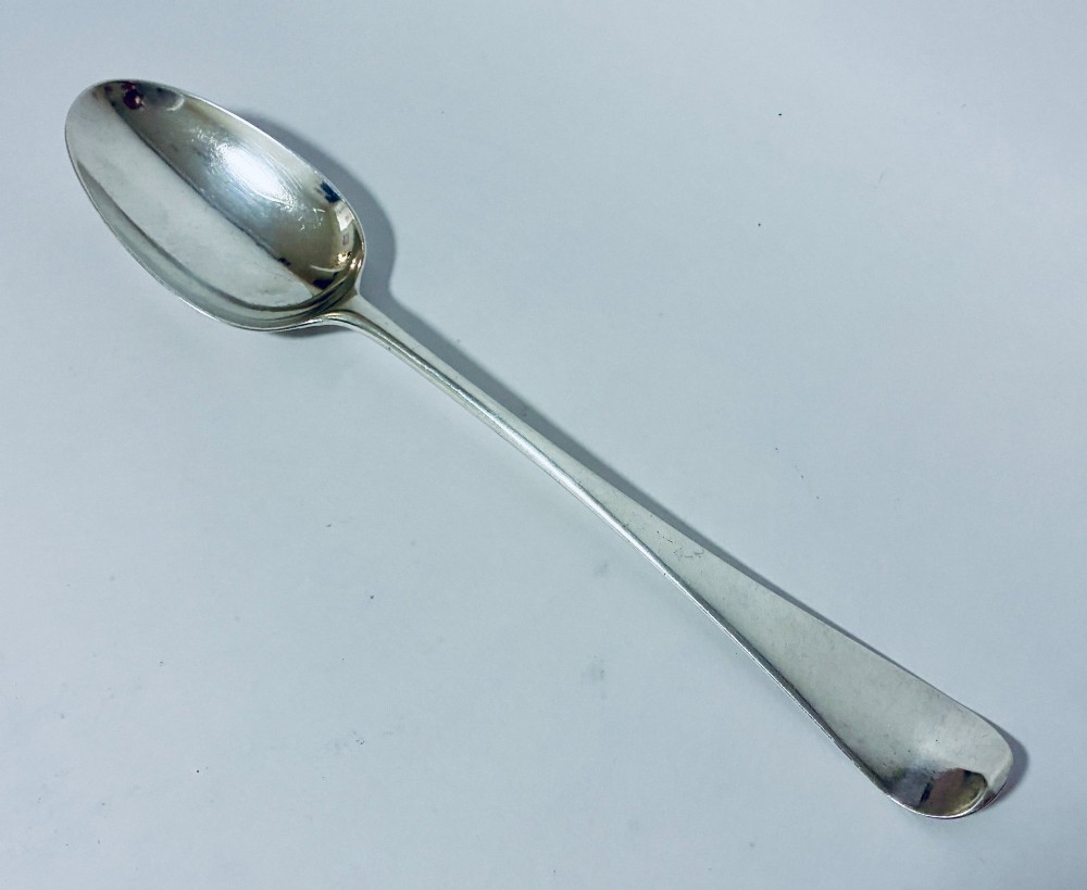 An 18th-century silver serving spoon featuring an elongated oval bowl and a smooth tapered handle. View II