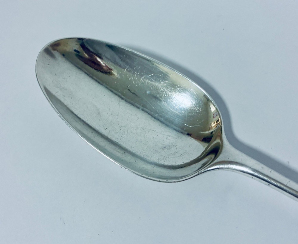 An 18th-century silver serving spoon featuring an elongated oval bowl and a smooth tapered handle. View IV
