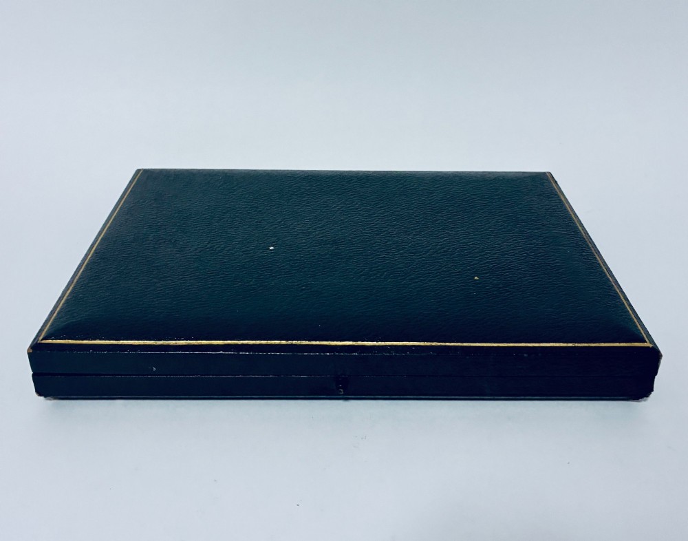 A cased set of six silver-handled butter knives with rounded blades displayed in a dark velvet-lined presentation box. View VIII