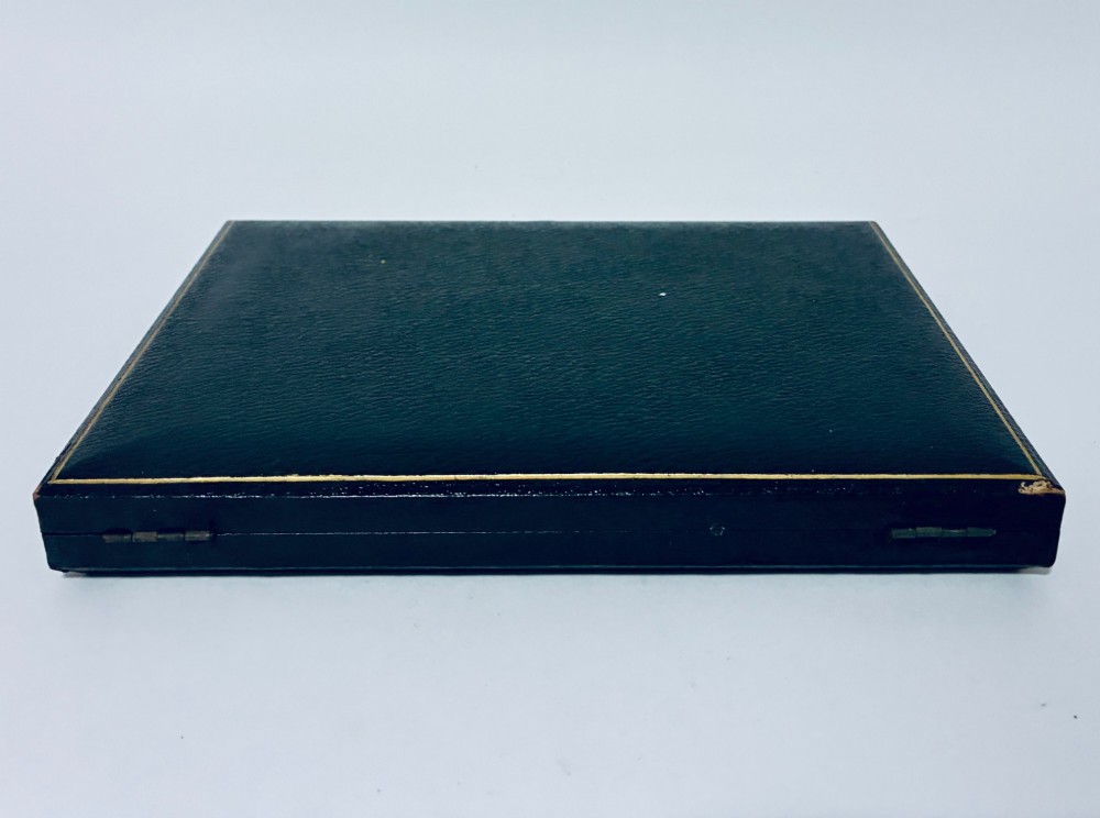 A cased set of six silver-handled butter knives with rounded blades displayed in a dark velvet-lined presentation box. View X