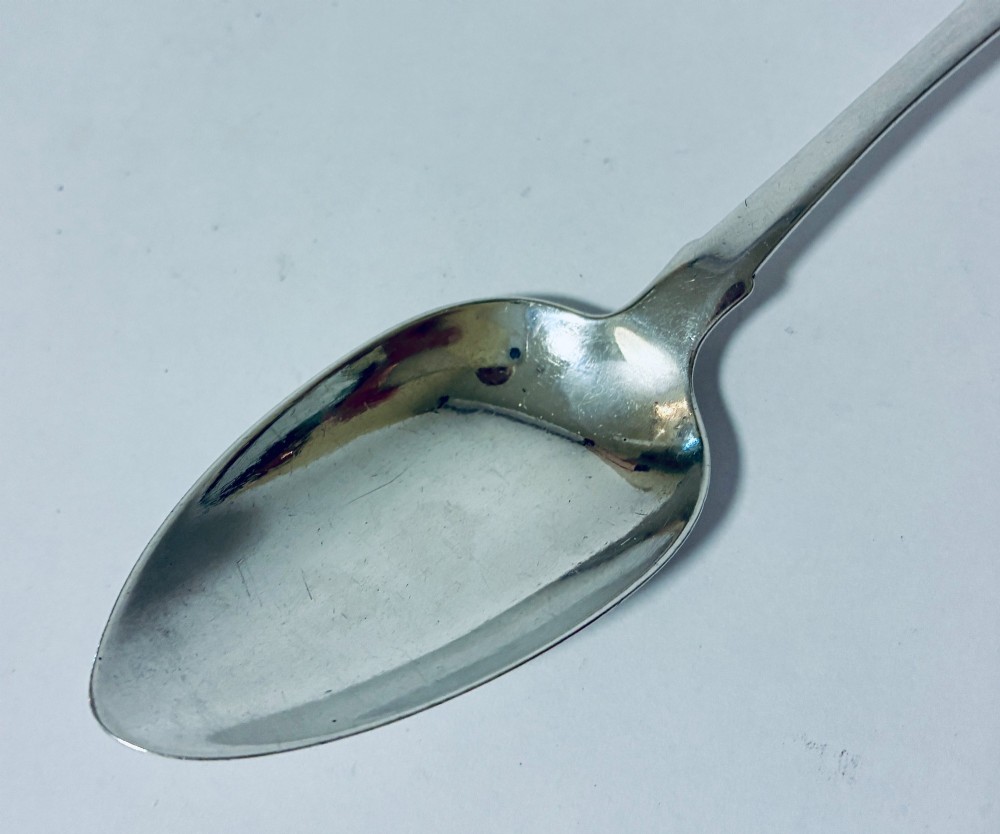An antique Exeter sterling silver tablespoon featuring a classic fiddle pattern handle with an engraved monogram. View IV