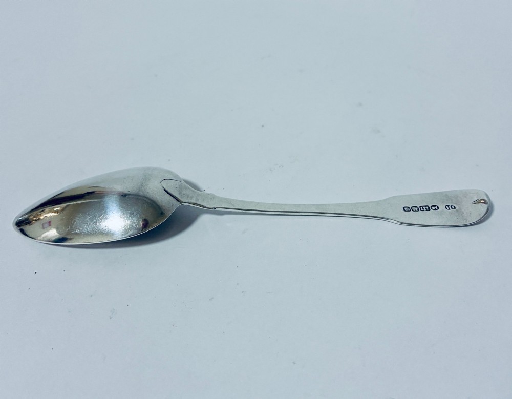 An antique Exeter sterling silver tablespoon featuring a classic fiddle pattern handle with an engraved monogram. View V