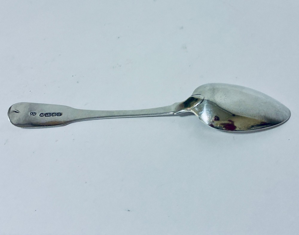 An antique Exeter sterling silver tablespoon featuring a classic fiddle pattern handle with an engraved monogram. View VI