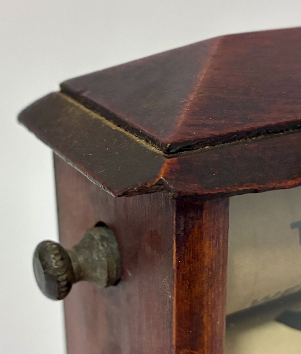An antique wooden perpetual desk calendar featuring rotating printed scrolls for days, dates, and months displayed behind glass with turning knobs. View VII