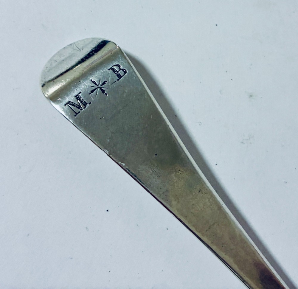 An 18th-century solid silver serving spoon featuring a plain tapered handle and an oval bowl. View VII