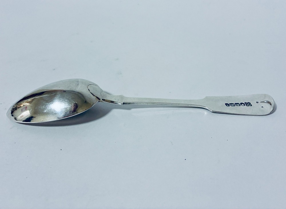 A sterling silver fiddle pattern tablespoon featuring an engraved monogram on the handle terminal and a polished oval bowl. View V