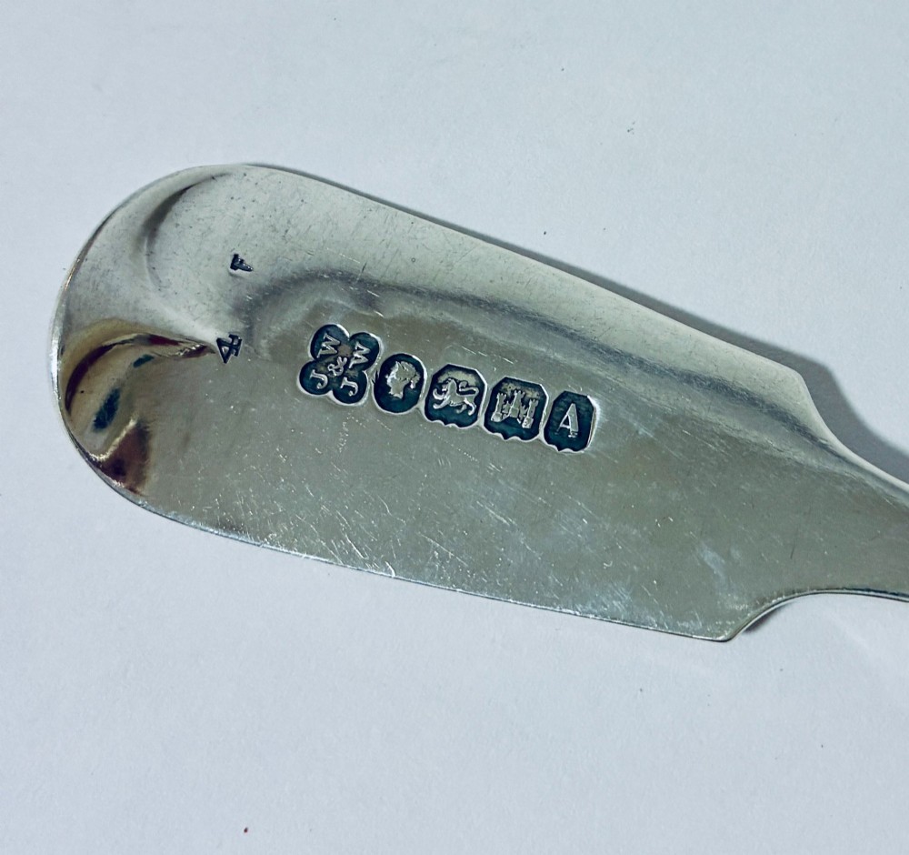 A sterling silver fiddle pattern tablespoon featuring an engraved monogram on the handle terminal and a polished oval bowl. View VI