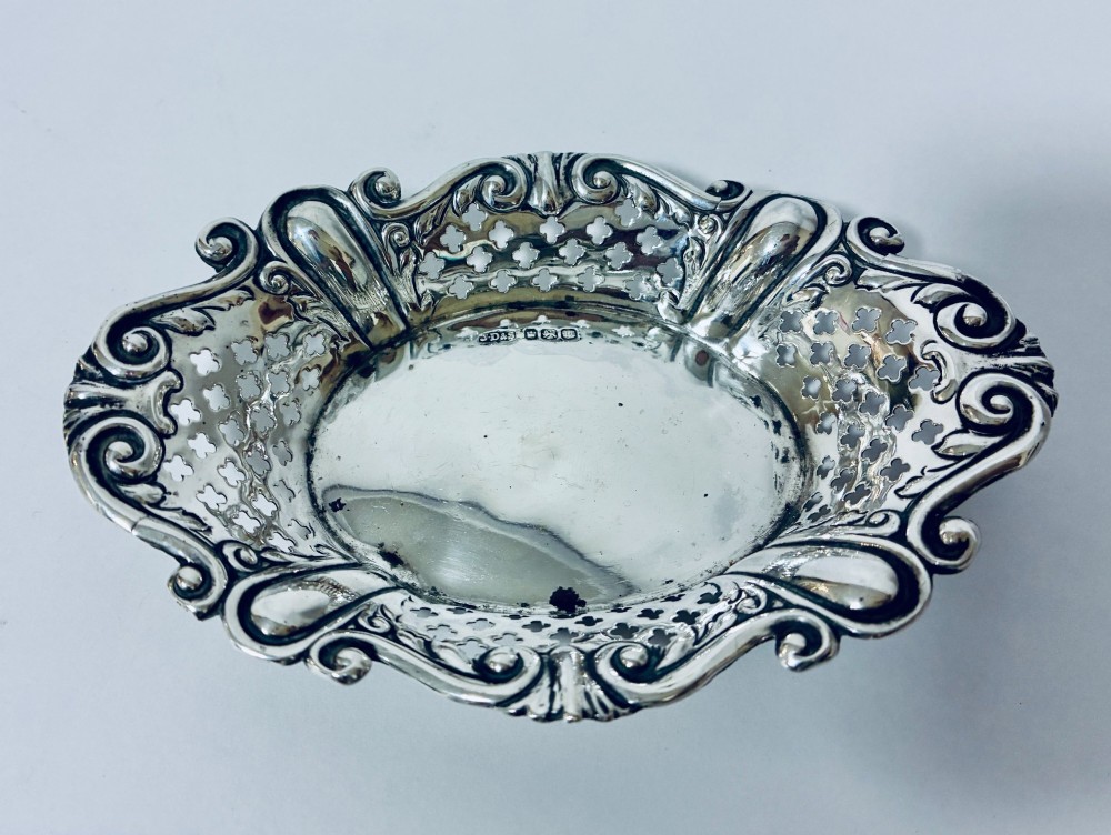 An oval antique silver bonbon dish featuring intricately pierced fretwork sides and a scrolled rim. View VII