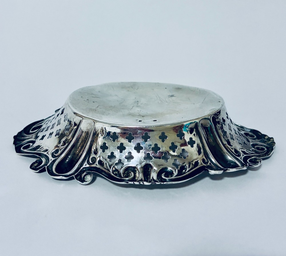 An oval antique silver bonbon dish featuring intricately pierced fretwork sides and a scrolled rim. View VIII