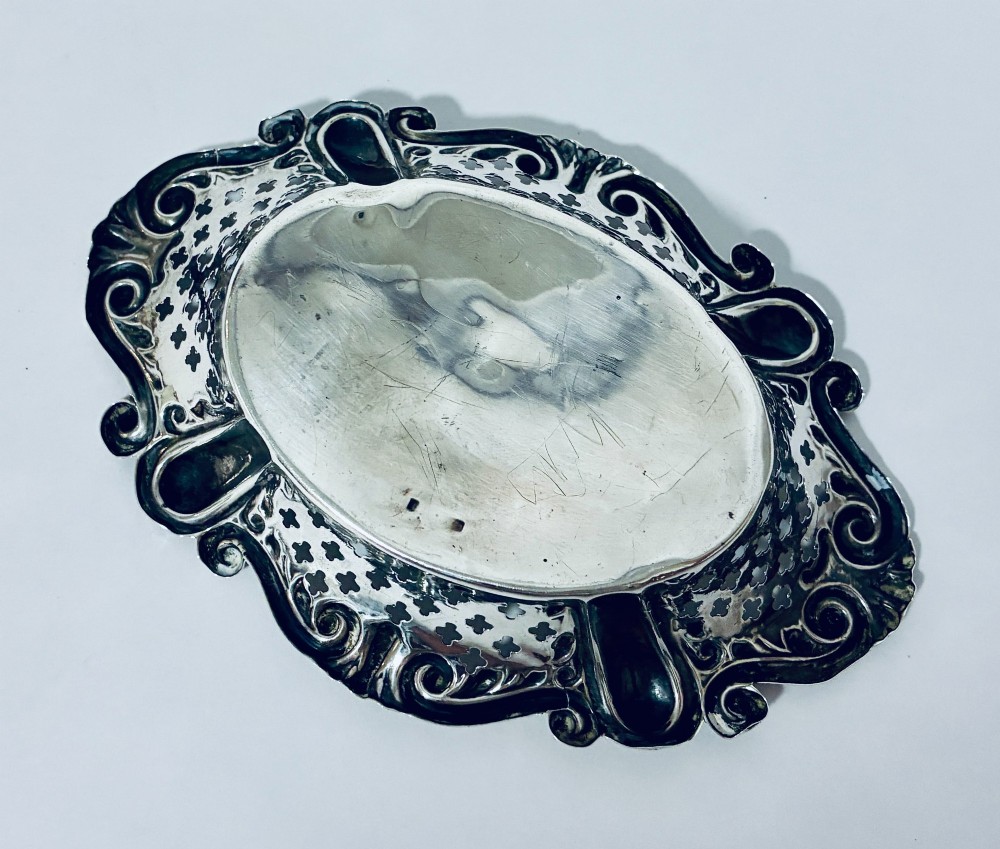 An oval antique silver bonbon dish featuring intricately pierced fretwork sides and a scrolled rim. View IX