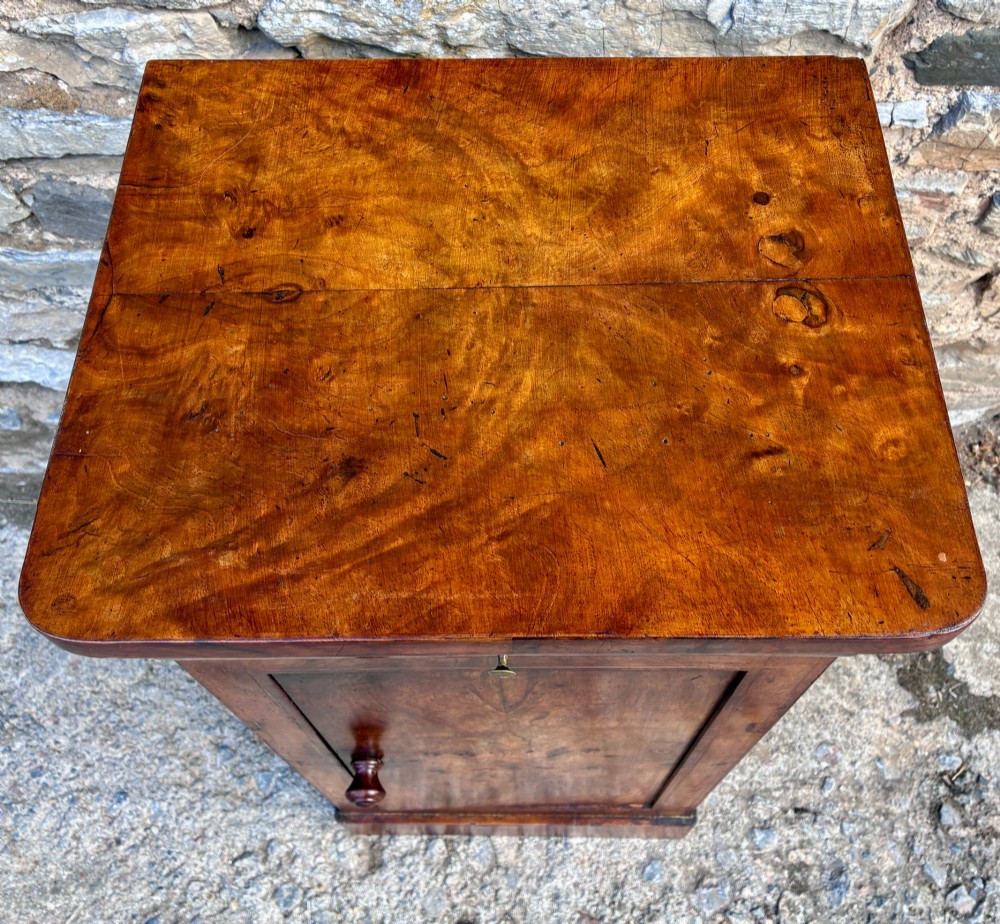 An antique French walnut pot cupboard with a figured burr walnut door panel, frieze drawer, and plinth base. View II