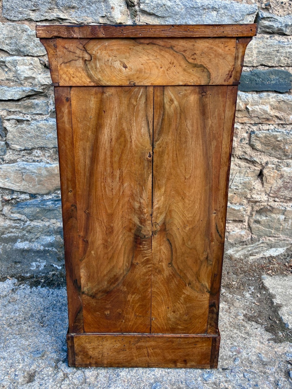 An antique French walnut pot cupboard with a figured burr walnut door panel, frieze drawer, and plinth base. View VII