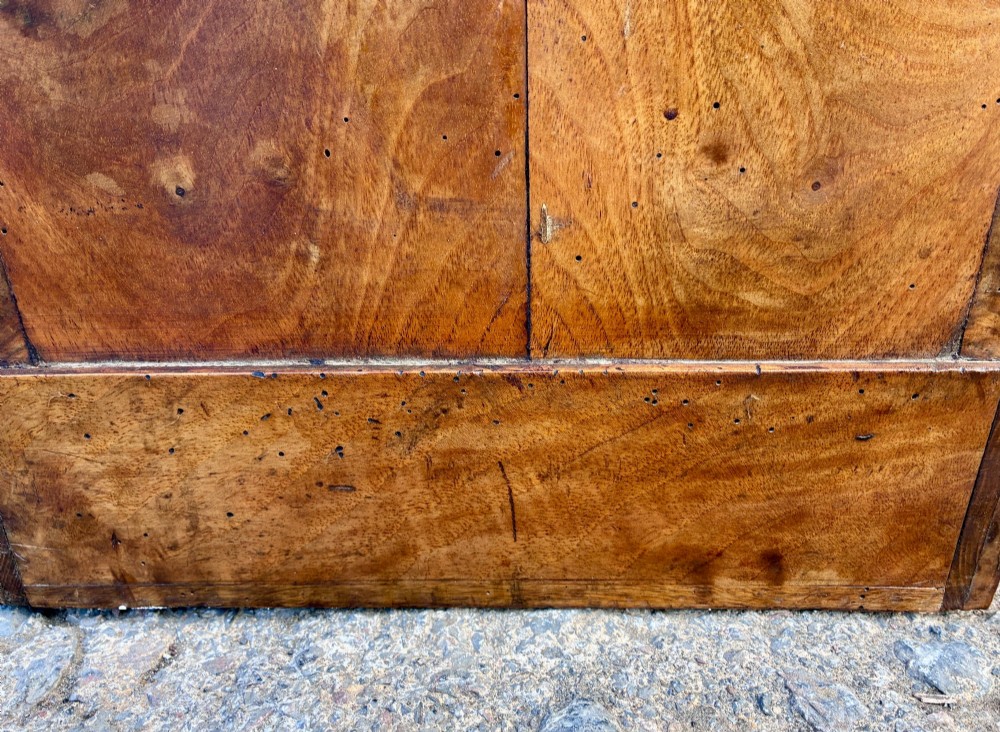 An antique French walnut pot cupboard with a figured burr walnut door panel, frieze drawer, and plinth base. View IX