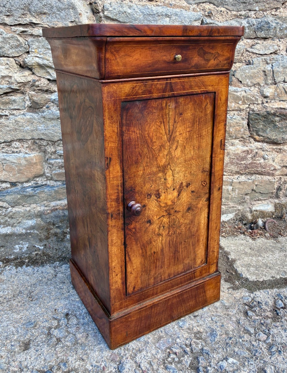 An antique French walnut pot cupboard with a figured burr walnut door panel, frieze drawer, and plinth base. View XI