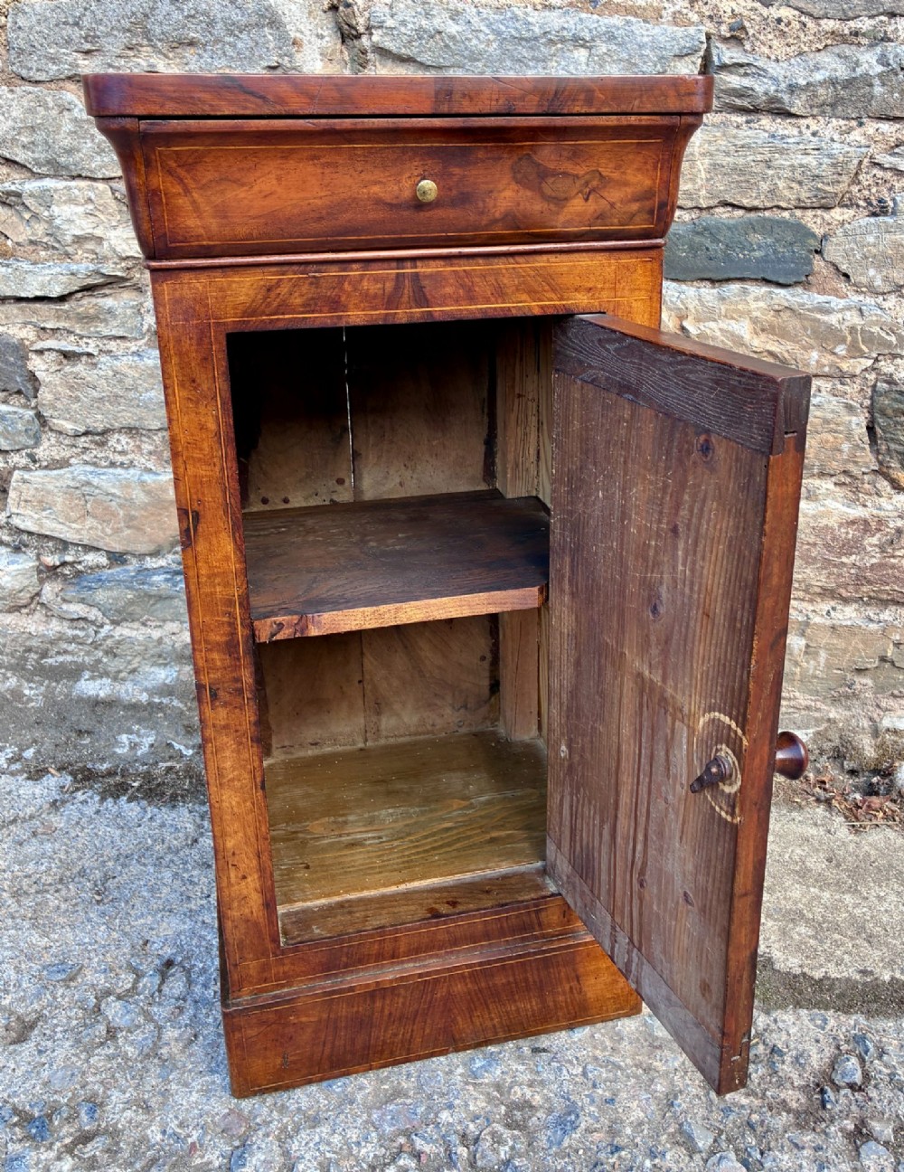 An antique French walnut pot cupboard with a figured burr walnut door panel, frieze drawer, and plinth base. View XIII
