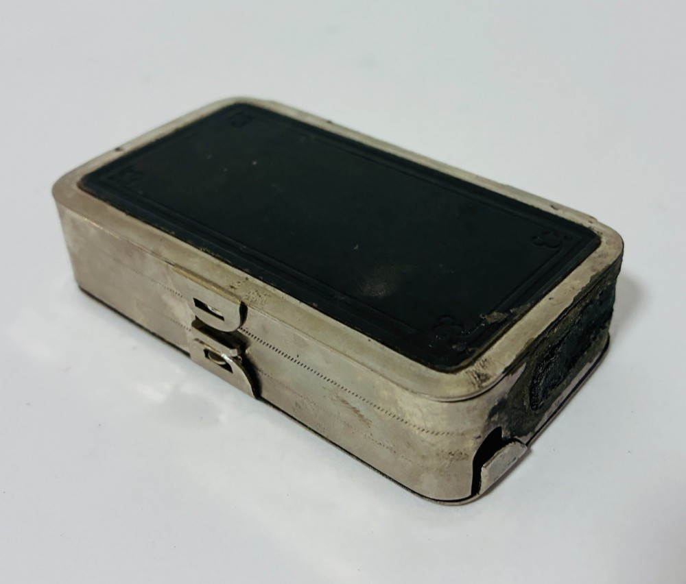 An open nickel-plated folding pocket lantern containing a small wax candle and a glass panel stamped with patent text. View XI