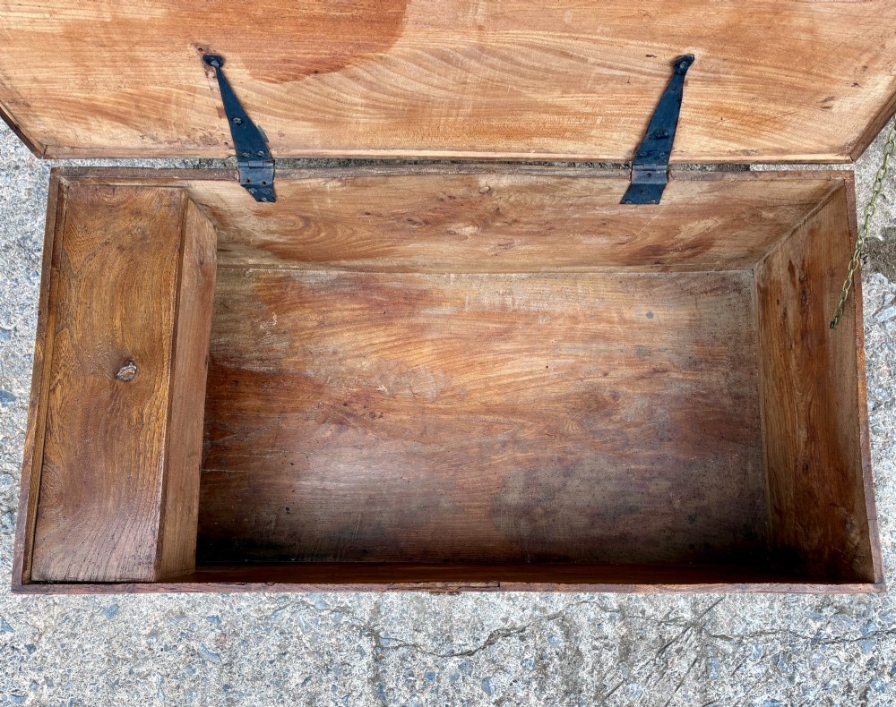 A low rectangular warm brown elm blanket box featuring a hinged top, polished finish, brass keyhole escutcheon, and bracket feet. View IV