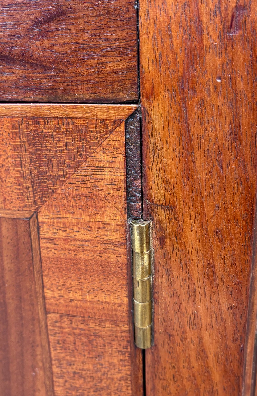 A Georgian mahogany pot cupboard featuring a tray top gallery with cut-out handles, a single veneered door, and turned legs. View XIII