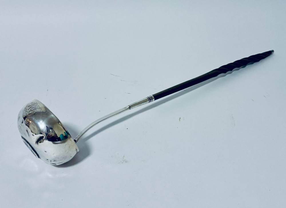 An antique Georgian silver toddy ladle featuring a deep circular silver bowl attached to a long, dark twisted handle. View II