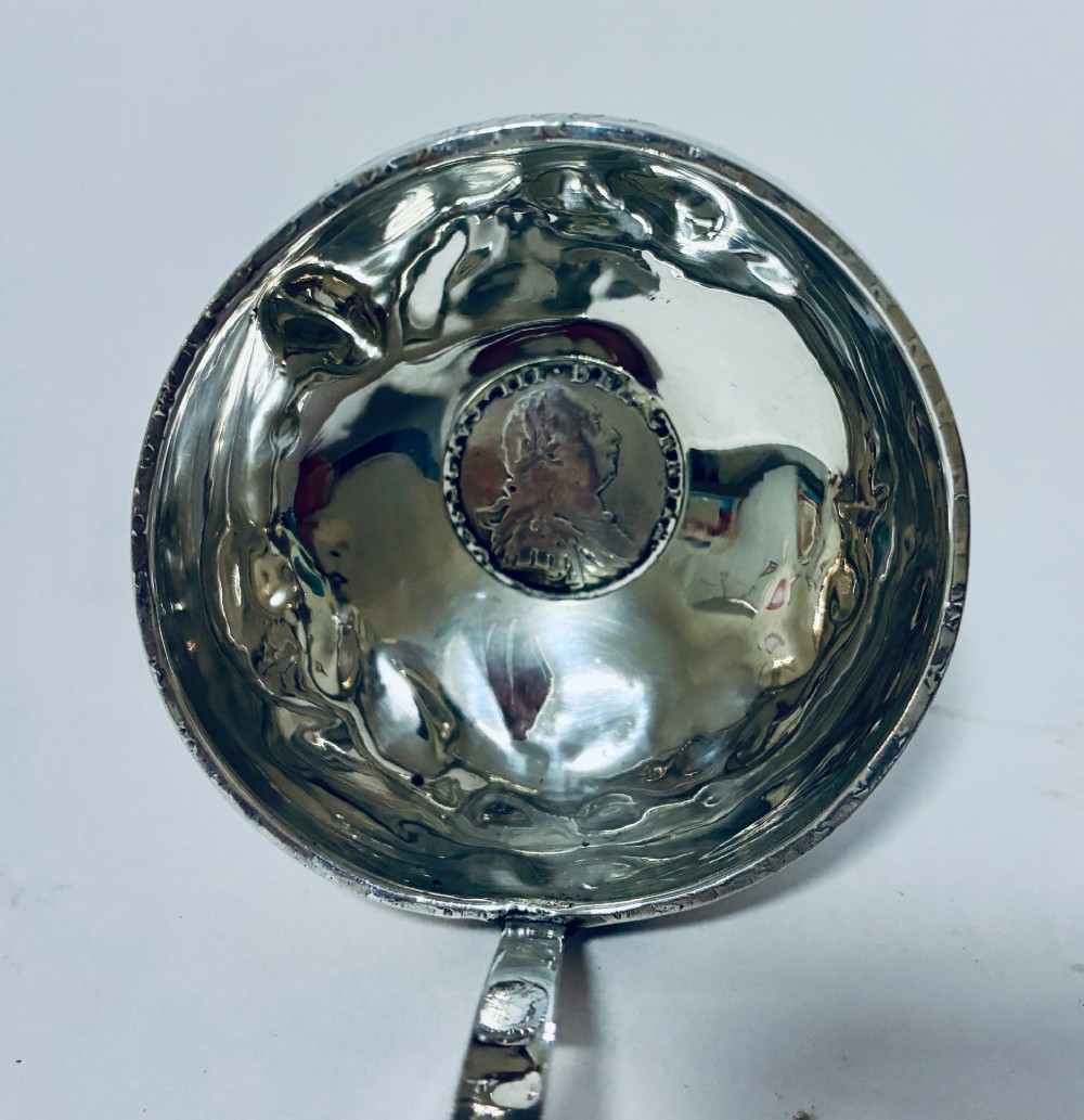 An antique Georgian silver toddy ladle featuring a deep circular silver bowl attached to a long, dark twisted handle. View IV