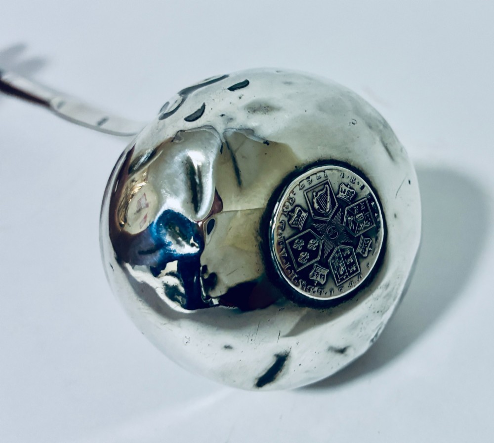An antique Georgian silver toddy ladle featuring a deep circular silver bowl attached to a long, dark twisted handle. View VI