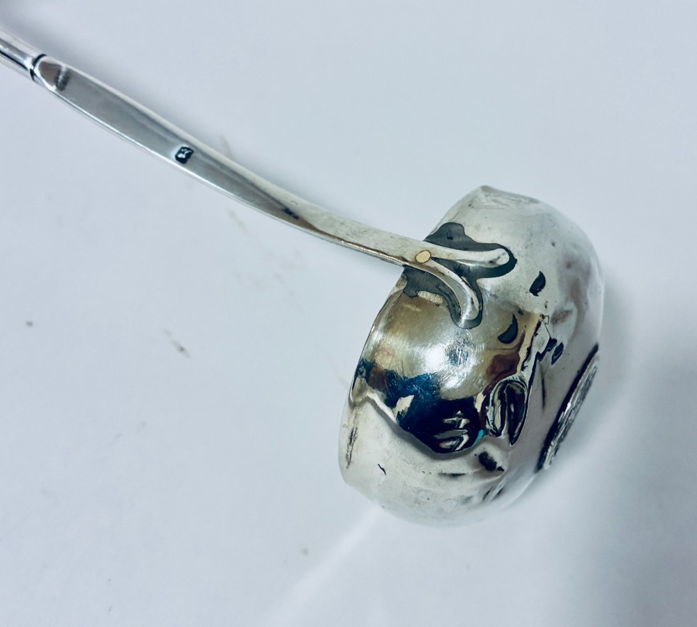 An antique Georgian silver toddy ladle featuring a deep circular silver bowl attached to a long, dark twisted handle. View VIII
