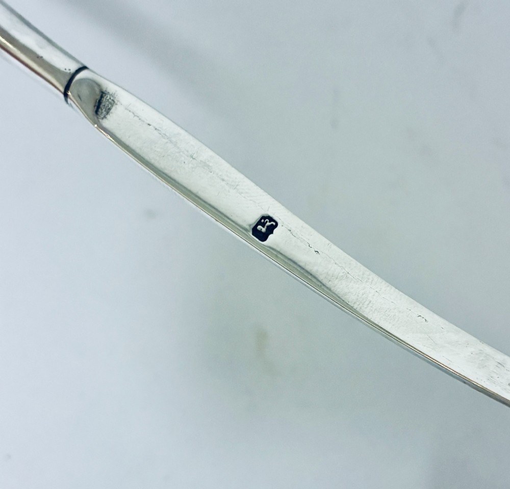 An antique Georgian silver toddy ladle featuring a deep circular silver bowl attached to a long, dark twisted handle. View XIII