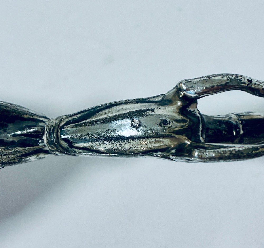 A pair of silver-plated knife rests sculpted in the form of running greyhounds with outstretched legs. View X