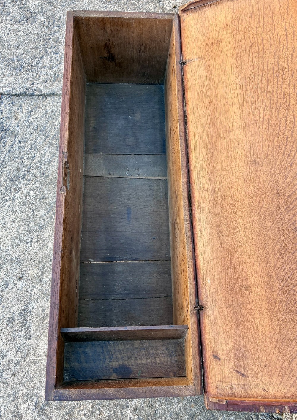 A long early 18th-century oak sword chest featuring a hinged lid, hand-carved initials H R, the date 1724 on the front panel, and a central iron escutcheon. View VI