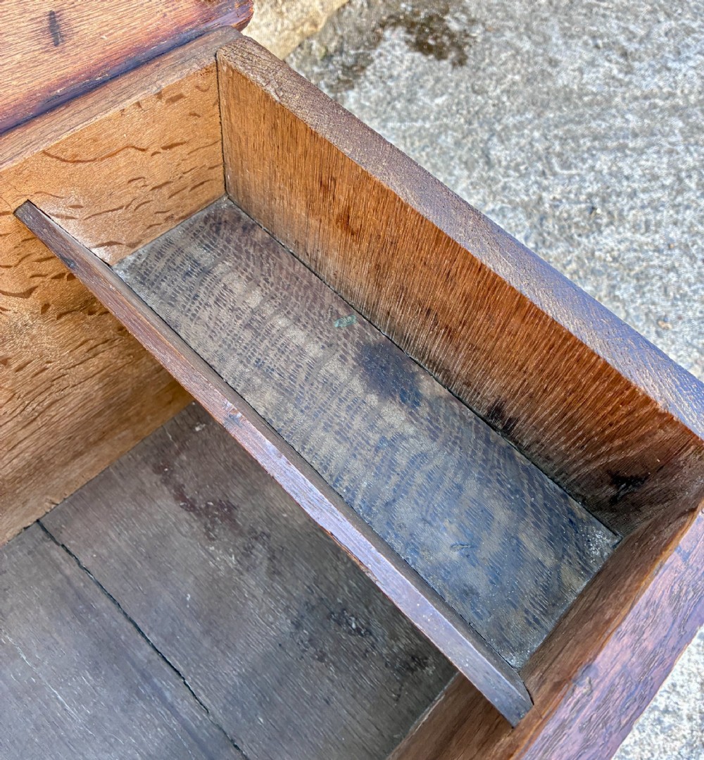A long early 18th-century oak sword chest featuring a hinged lid, hand-carved initials H R, the date 1724 on the front panel, and a central iron escutcheon. View VII