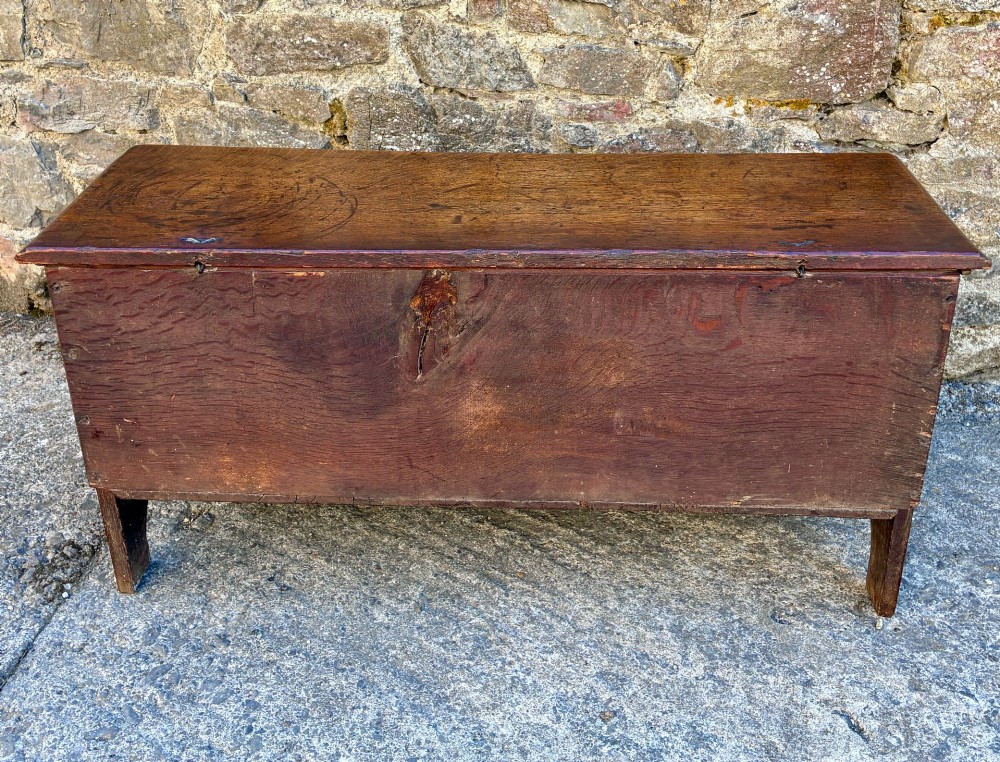 A long early 18th-century oak sword chest featuring a hinged lid, hand-carved initials H R, the date 1724 on the front panel, and a central iron escutcheon. View XII