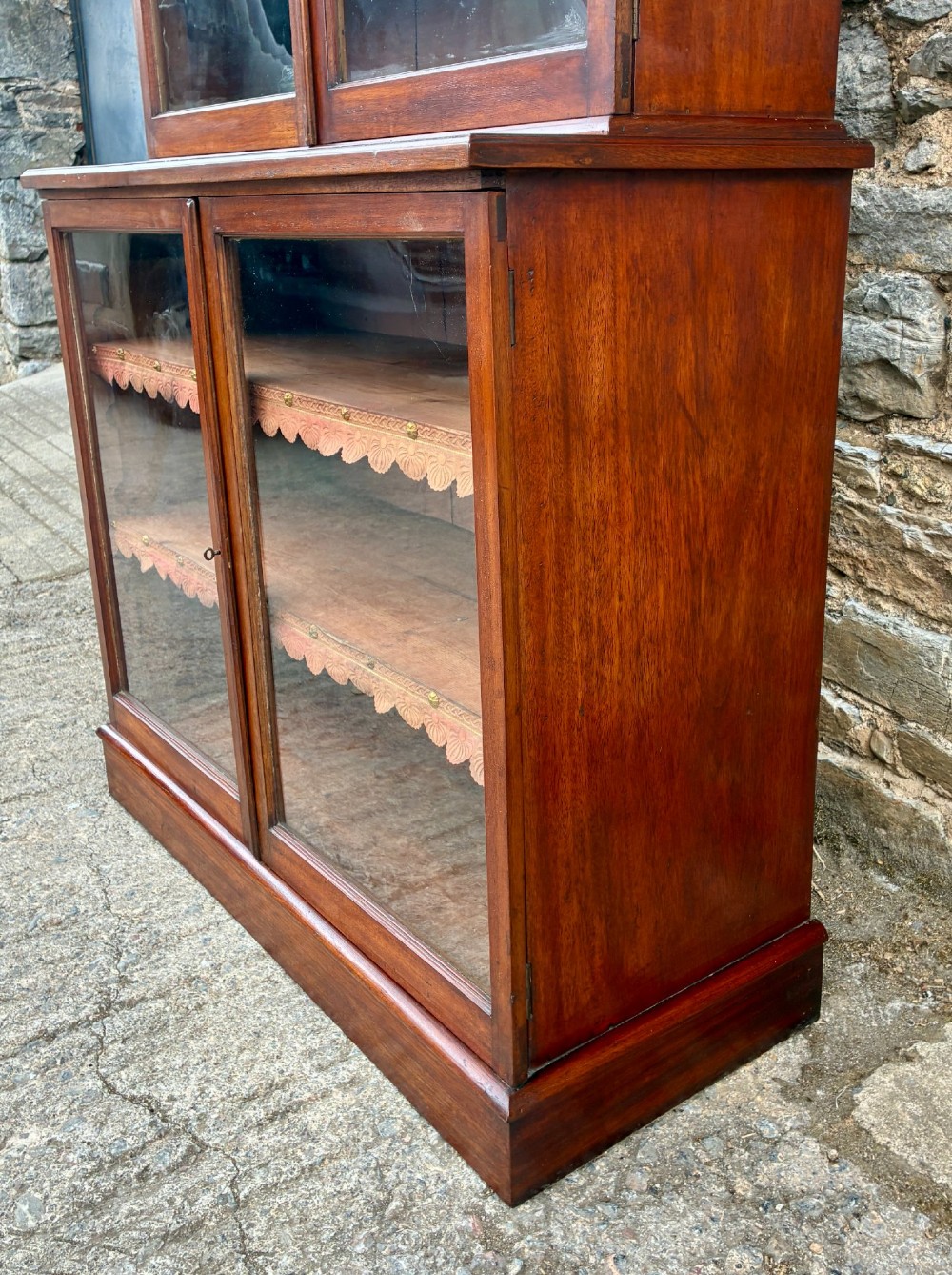A tall Victorian mahogany cabinet featuring an upper two-door glazed section with scalloped shelf edging set above a lower matching glazed cupboard. View VI