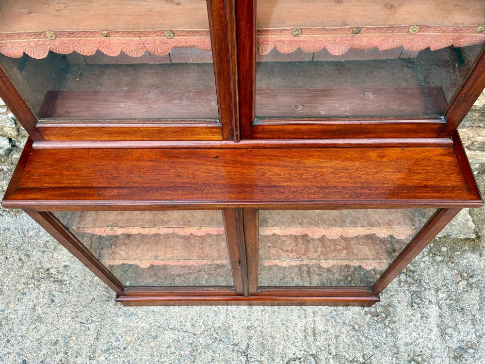 A tall Victorian mahogany cabinet featuring an upper two-door glazed section with scalloped shelf edging set above a lower matching glazed cupboard. View VII