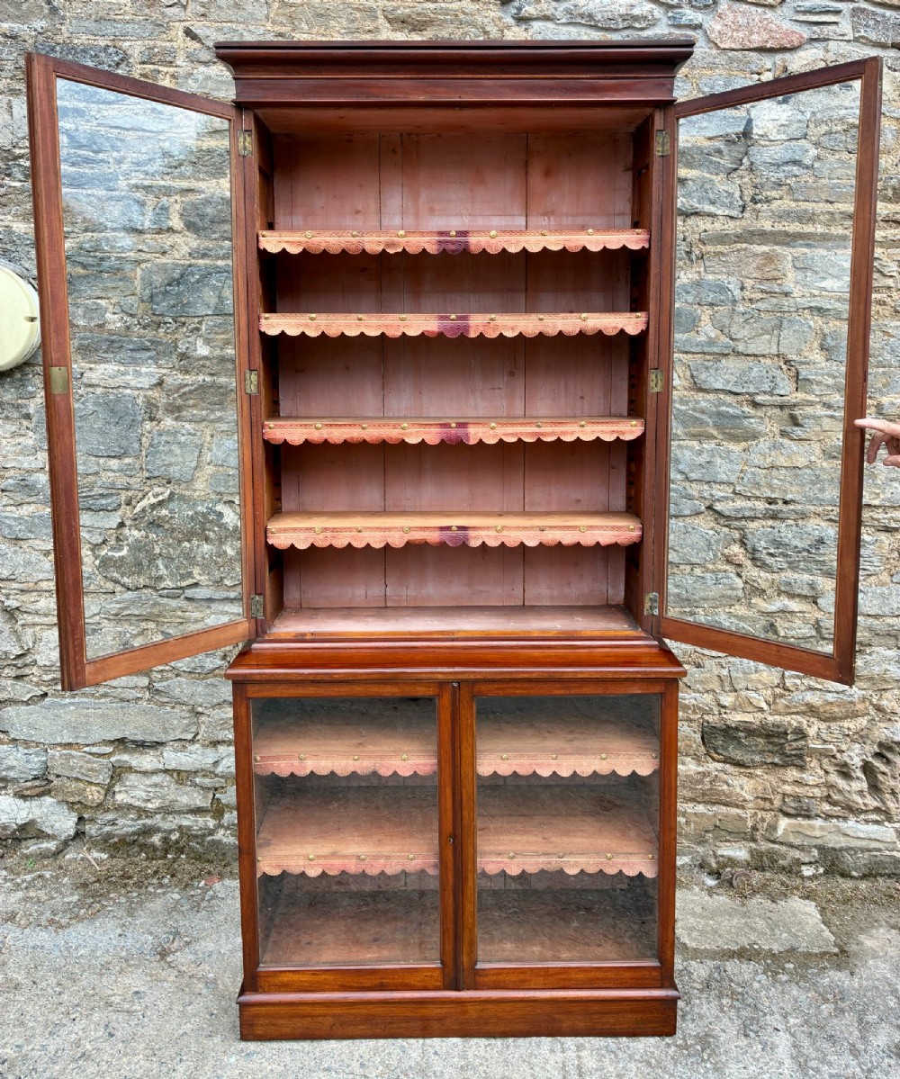 A tall Victorian mahogany cabinet featuring an upper two-door glazed section with scalloped shelf edging set above a lower matching glazed cupboard. View VIII