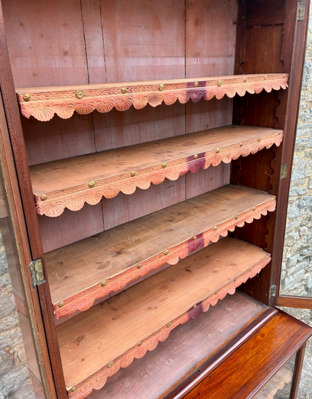 A tall Victorian mahogany cabinet featuring an upper two-door glazed section with scalloped shelf edging set above a lower matching glazed cupboard. View X