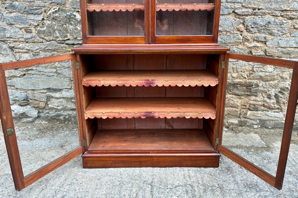 A tall Victorian mahogany cabinet featuring an upper two-door glazed section with scalloped shelf edging set above a lower matching glazed cupboard. View XII